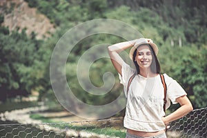 Brunette girl in park in straw hat.