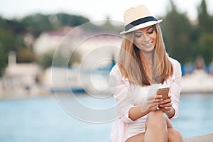 Brunette girl relaxing on the beach with phone