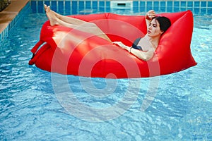 Brunette girl relaxing in the pool