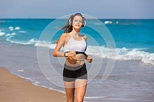 Brunette girl running on the beach headphones