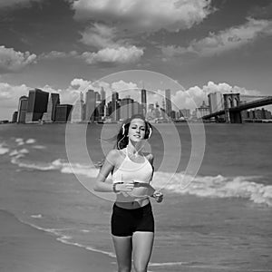 Brunette girl running in New York Brooklyn bridge