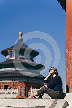 Brunette girl sitting on the steps by temple of heven in China