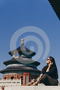 Brunette girl sitting on the steps by temple of heven in China