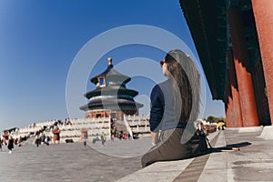 Brunette girl sitting on the steps by temple of heven in China