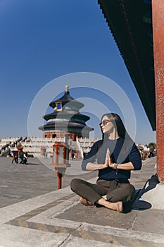 brunette girl sitting on the steps by temple of heven in China