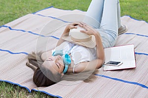 Brunette girl sleep on mat in grass field