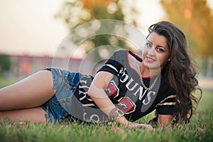 brunette girl with sporty body wearing jeans shorts.street fashion of contemporary youth girl.beautiful brunette girl resting