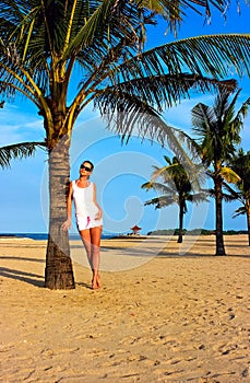 Brunette girl standing on the lonely sand beach