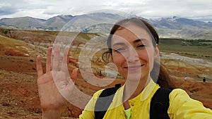 Brunette girl takes a selfie on the background of the Altai Mars in the Altai Republic in Russia. Mount Kyzyl Chin. A trip