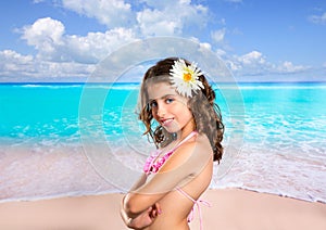 Brunette girl in tropical beach with daisy flower happy