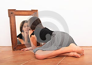 Brunette girl watching herself in mirror