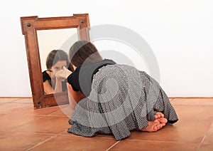 Brunette girl watching herself in mirror