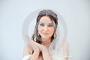 Brunette girl in a wedding dress. Bride in a white dress. Makeup. photo