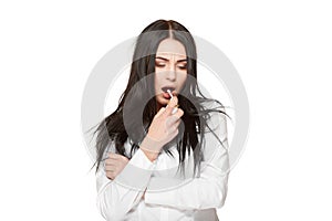 Brunette girl on white using spray for throat, anti flu medicament.