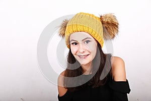 Brunette girl in in yellow cap with brown bobbles