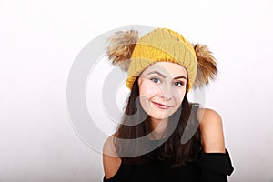 Brunette girl in in yellow cap with brown bobbles