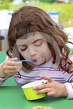 Brunette little girl eating ice cream