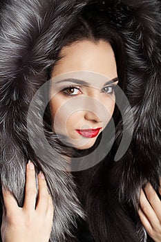 Brunette with long beautiful hair, dressed in a coat. Cool young girl. Professional makeup. Winter theme. Red lips.