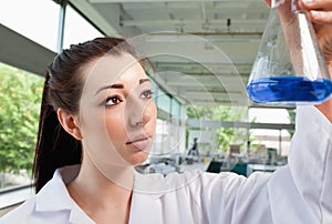 Brunette looking at an Erlenmeyer flask