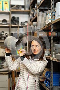 Brunette looking for plumbing fittings in construction hypermarket