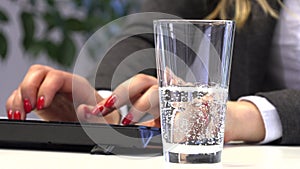 Brunette Manager pours water into a glass for drinking