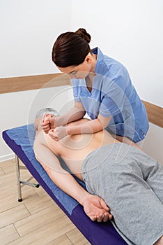 brunette masseuse doing back massage to