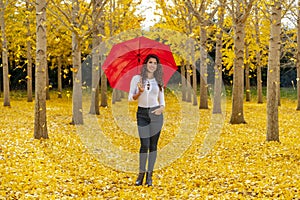 Brunette Model Enjoying A Fall Day In Fall Foliage With A Red Umbrella