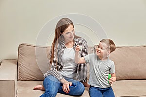 A brunette mom with a child in the house blowing bubbles. Summer game.