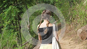 Brunette in open shoulders top walks along green meadow