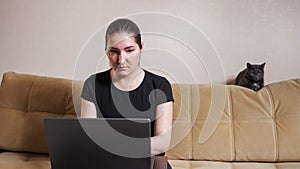 Brunette with ponytail looks into laptop display at home