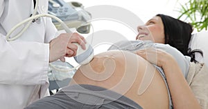 Brunette pregnant woman having a sonogram scan