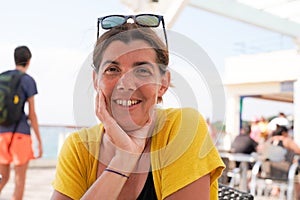 Brunette pretty smiling middle aged woman outdoors happiness on bar terrace beach coast