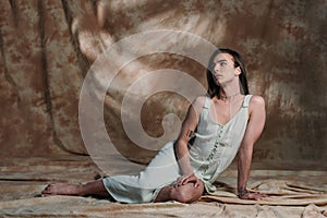 Brunette queer person in dress sitting