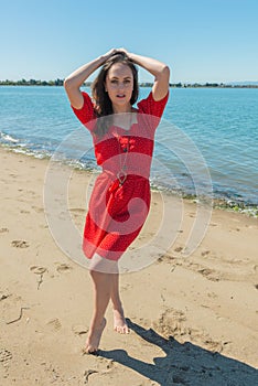 Brunette in red on a beach