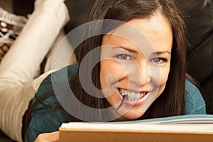 Brunette relaxing at home with book.