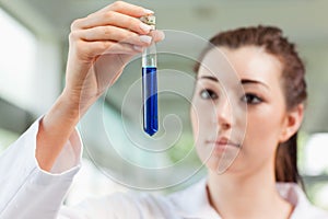 Brunette scientist looking at a test tube