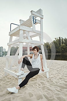 Brunette with short haircut sitting on volleyball seat