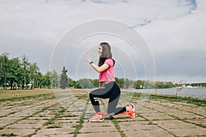 Brunette slim adult sexy fit sporty woman in sportswear on a european city streets in morning do exercises. photo