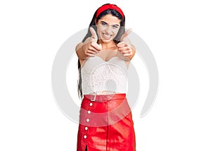 Brunette teenager girl wearing elegant look approving doing positive gesture with hand, thumbs up smiling and happy for success