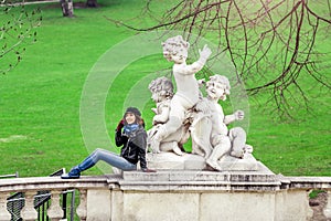 Brunette traveler woman talking and using cell phone in the garden, roaming and phone connection abroad concept