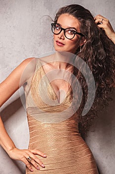 Brunette wearing glasses poses while fixing her hair