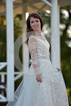 Brunette in a white dress in the park photo