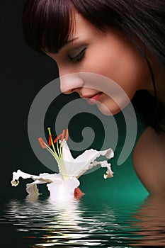 Brunette with white lily flowers in water