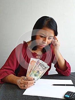 brunette woman analyzing economic budget and holding Honduran money