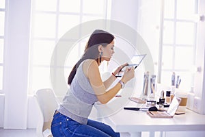 Brunette woman applying make up for a evening date in front of a mirror