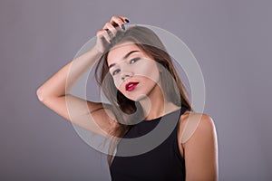 Brunette Woman with beauty makeup and red lips over gray background