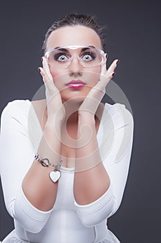 Brunette Woman With Both Hands Lifted Near Face. Against Gray Background photo