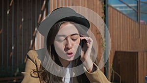 Brunette woman is calling by smartphone and talking joyfully, close-up of face