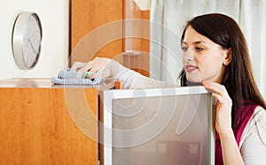 Brunette woman cleaning furiture