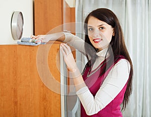 Brunette woman cleaning furiture with rag